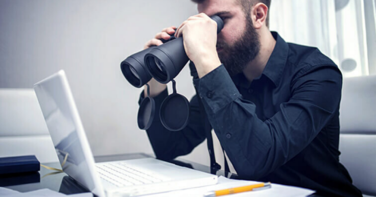 A student looking for IELTS Classes in Ludhiana on Laptop using a Binoculars