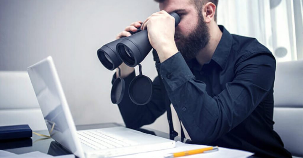 A student looking for IELTS Classes in Ludhiana on Laptop using a Binoculars