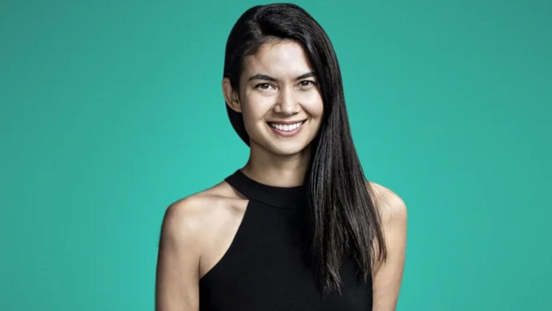 Melanie Perkins is giving a pose in an elegant black top